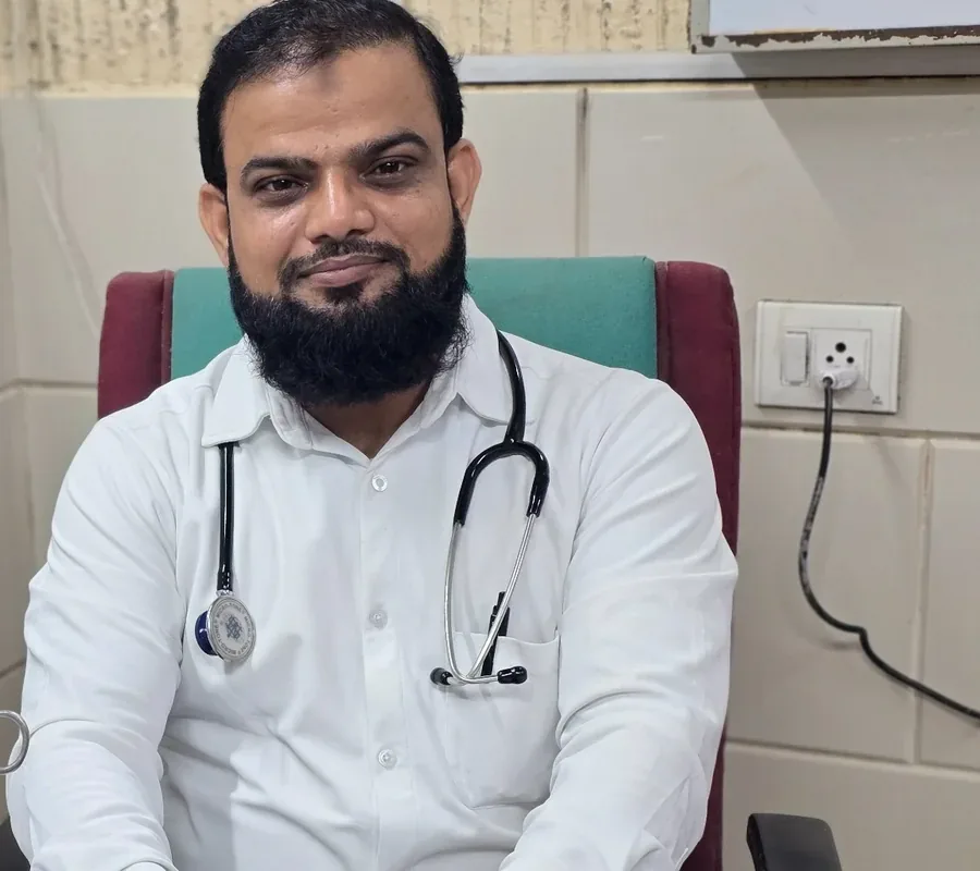 Dr. Shams Alam seated in his clinic wearing a stethoscope